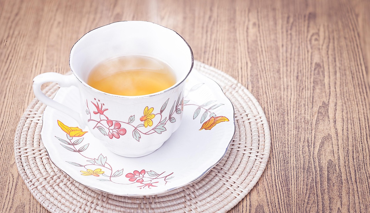 Tazza di tè fumante su tavolo, ideale per sgonfiare la pancia a metà mattina.