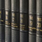 Collezionista esamina un'antica enciclopedia in un mercato di antiquariato.