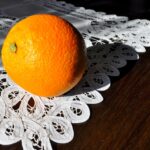 Vecchi centrini della nonna esposti su un tavolo, simbolo di tradizione e valori artigianali.